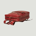 Zaino in pelle rossa con zip orizzontale e fibbie laterali, dettagli in metallo