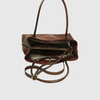 Borsa in pelle mogano aperta con interno scuro e tracolla regolabile