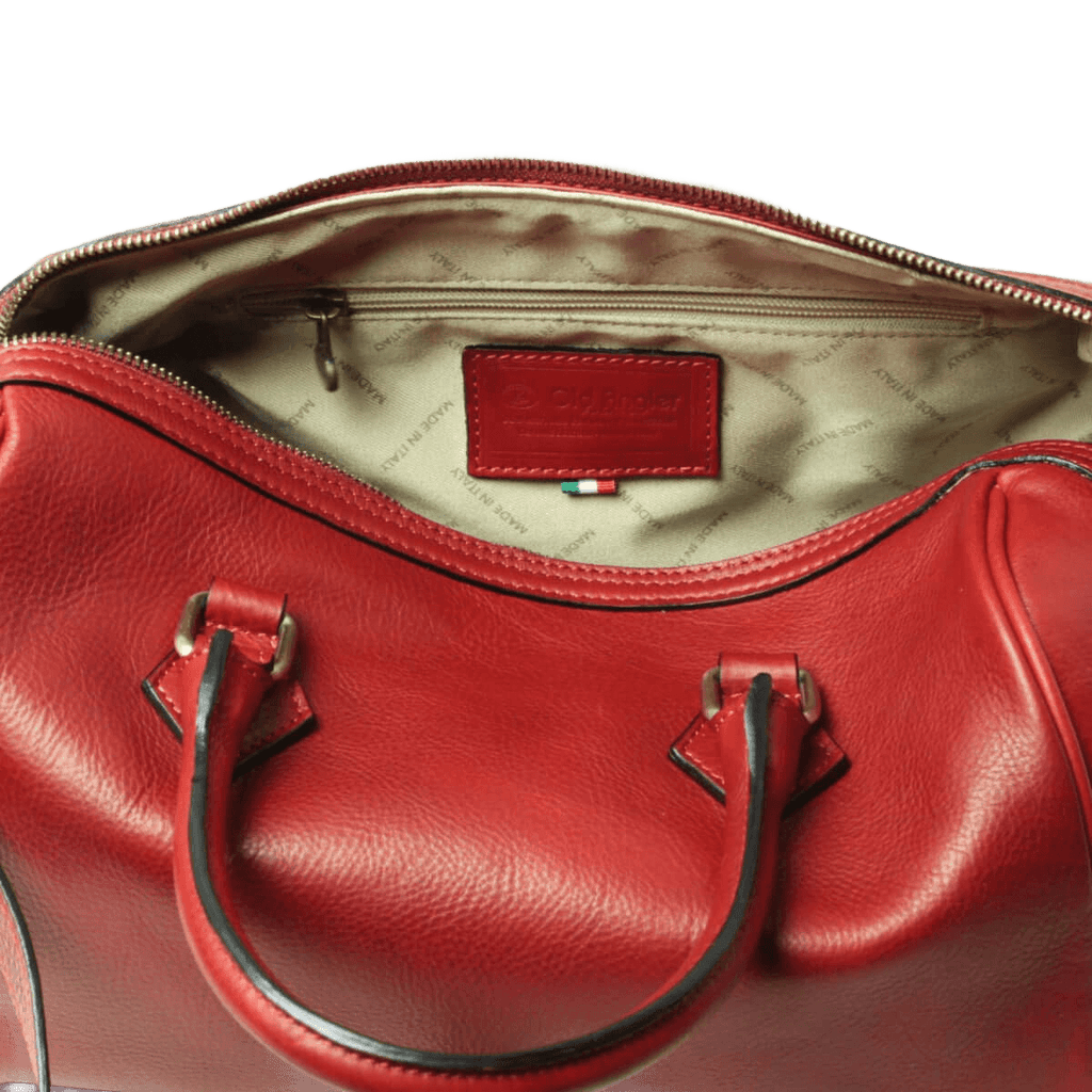 Interno di bauletto in pelle rossa con fodera chiara e etichetta Old Angler.