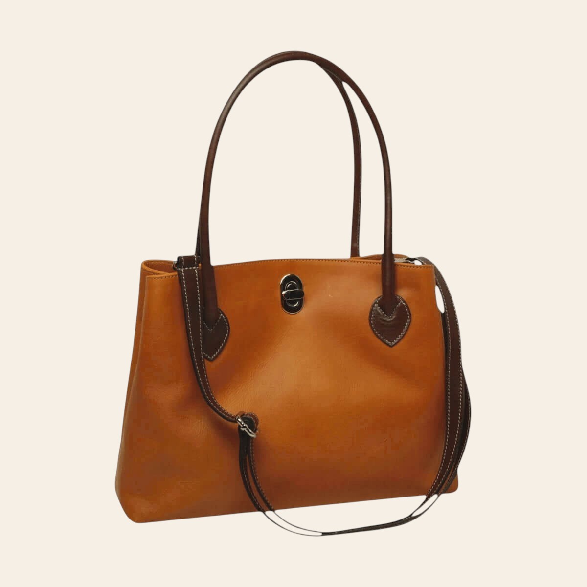 Borsa in pelle bicolore giallo ocra con manici e bordi marrone scuro, chiusura frontale.