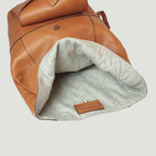 Zaino in pelle marrone con interno imbottito bianco e tasca interna in pelle.