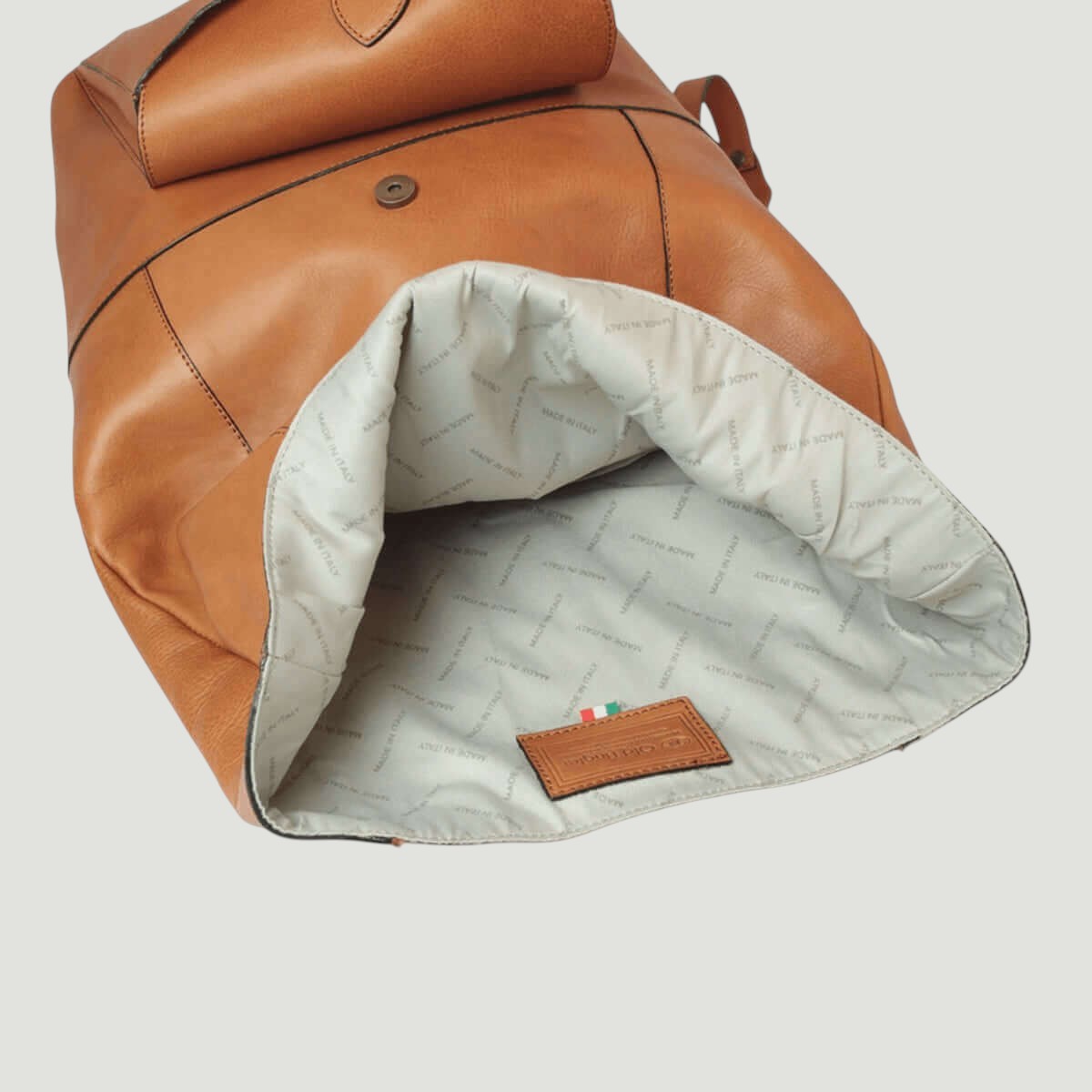 Zaino in pelle marrone con interno imbottito bianco e tasca interna in pelle.