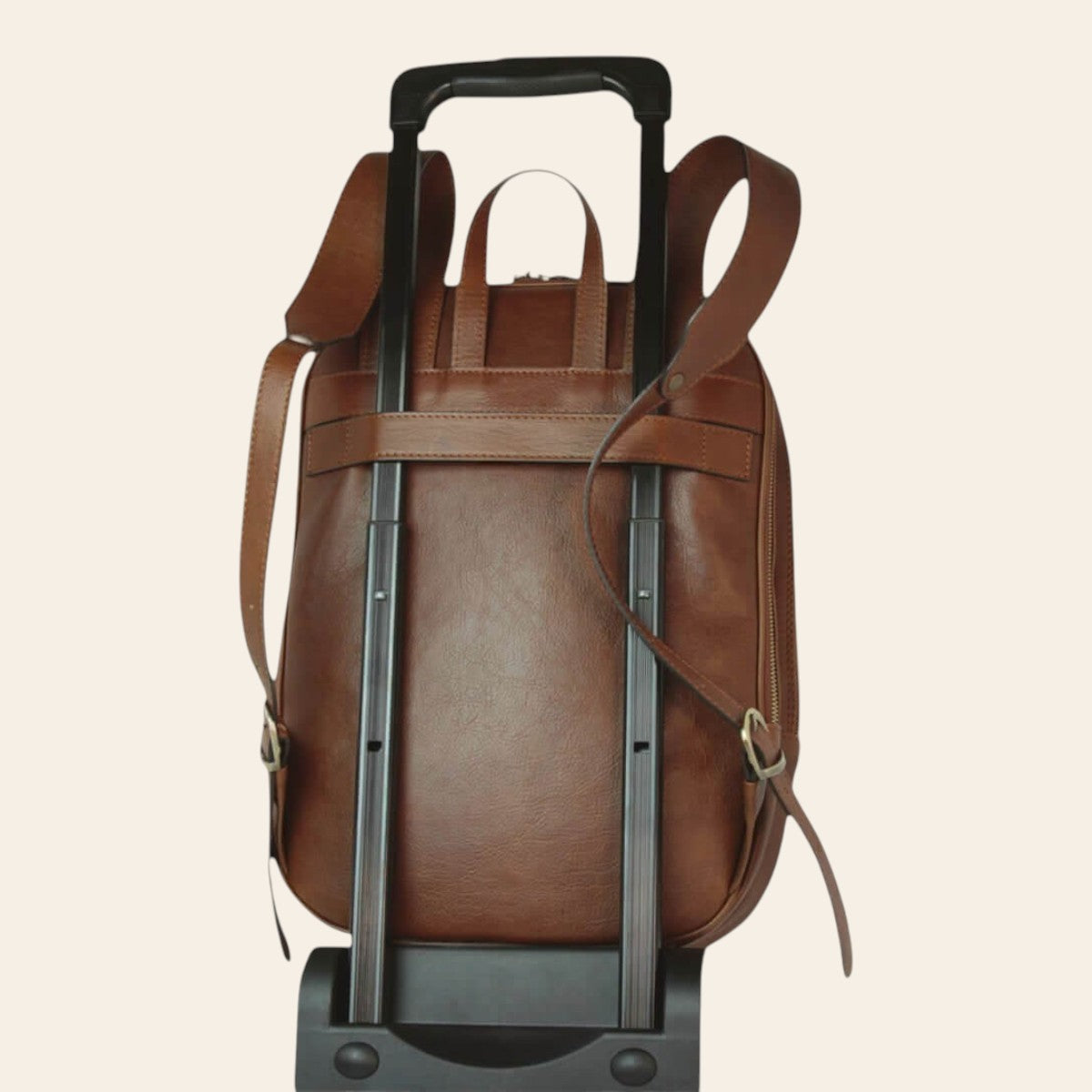 Rückansicht des kastanienbraunen Rucksacks aus Leder, mit der hinteren Schlaufe am Trolley befestigt