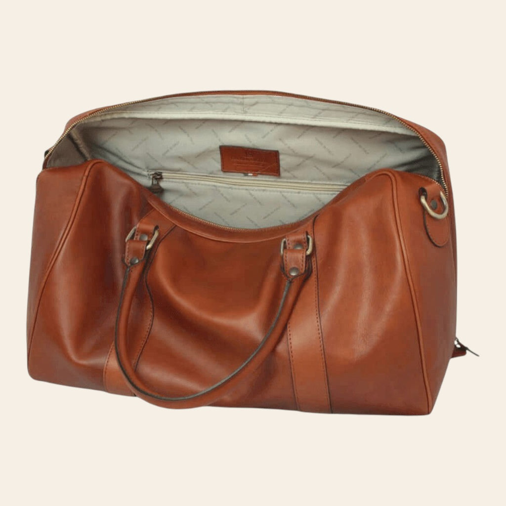 Sac de voyage en cuir cognac chaud, ouvert avec doublure claire imprimée et poche intérieure zippée