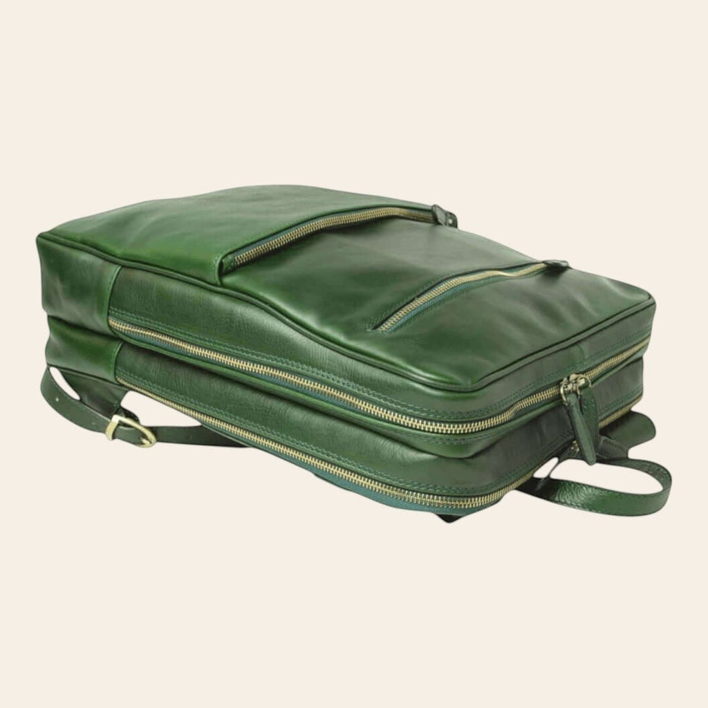 Mochila de piel de becerro en color verde, colocada en horizontal con bolsillos frontales y dos compartimentos con cremallera