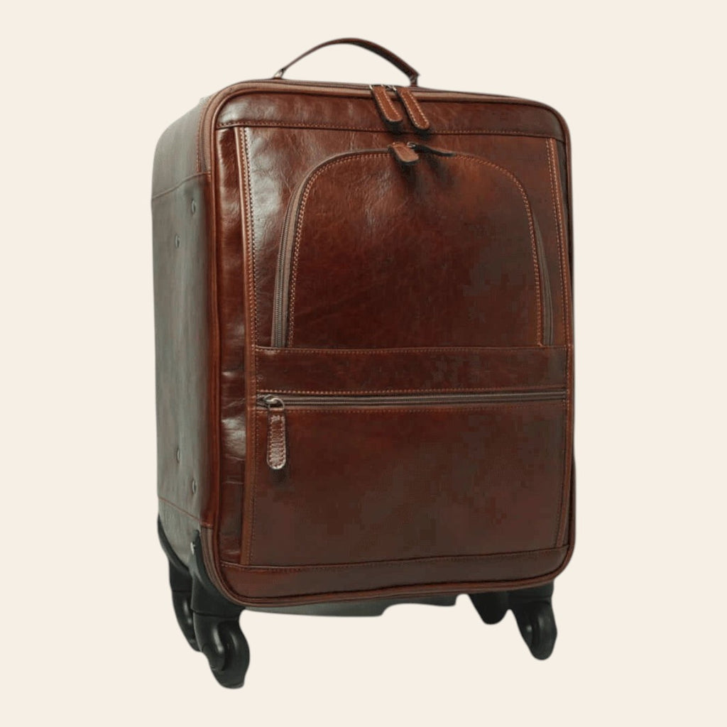 Trolley in pelle marrone con maniglia superiore e tasca frontale con zip; ruote.