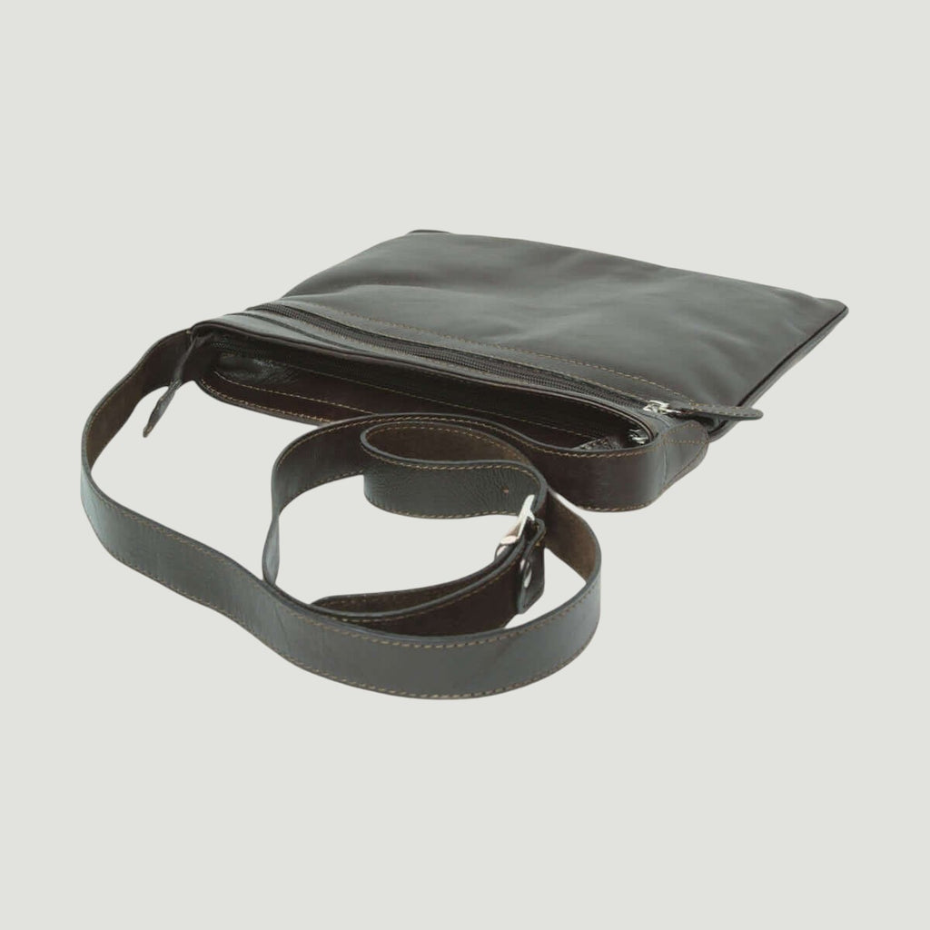 Borsa a tracolla in pelle scura vista dall’alto, tasca con zip e patta superiore