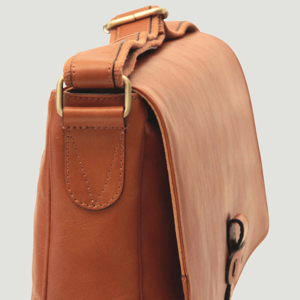 Borsa messenger in pelle marrone vista laterale, tasca frontale e fibbia superiore.