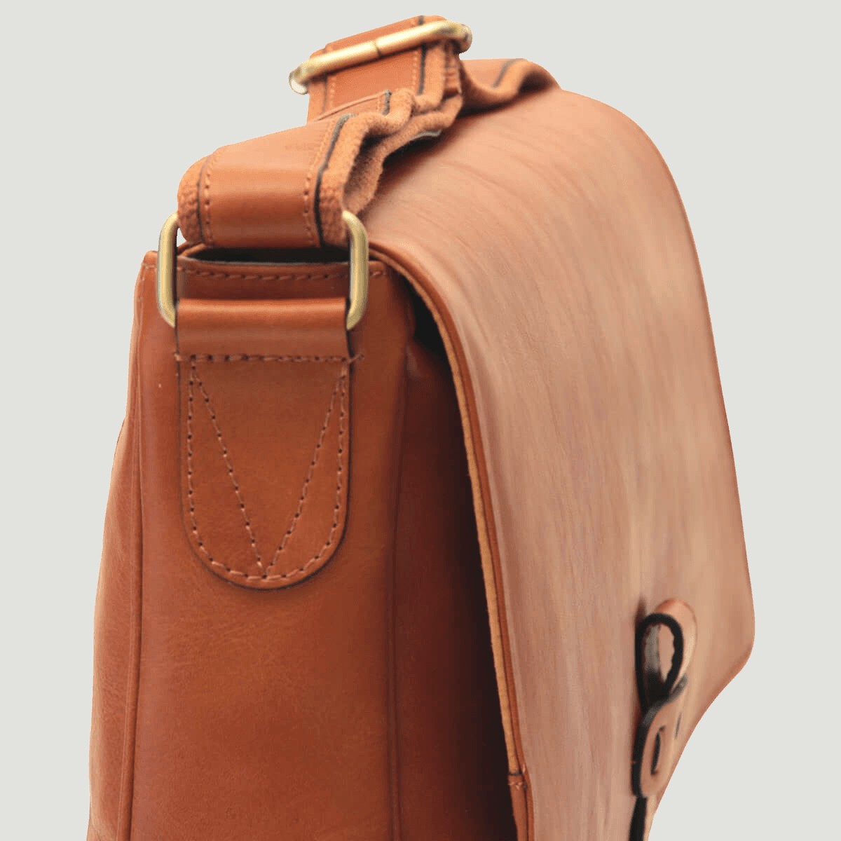 Borsa messenger in pelle marrone vista laterale, tasca frontale e fibbia superiore.