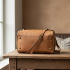 Bauletto in pelle color cuoio con patta frontale e borchie, tracolla regolabile