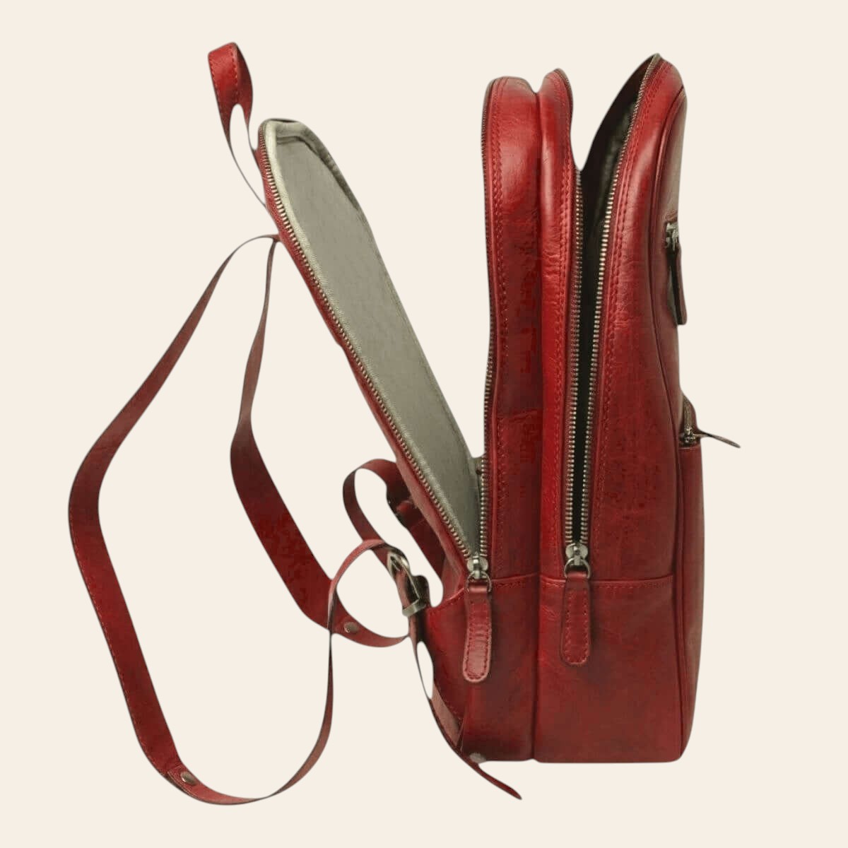 Seitenansicht eines Rucksacks aus vollnarbigem Kalbsleder in Rot mit Reißverschluss und verstellbarem Schulterriemen