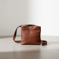 Borsa a secchiello in pelle marrone con tracolla regolabile e fibbia