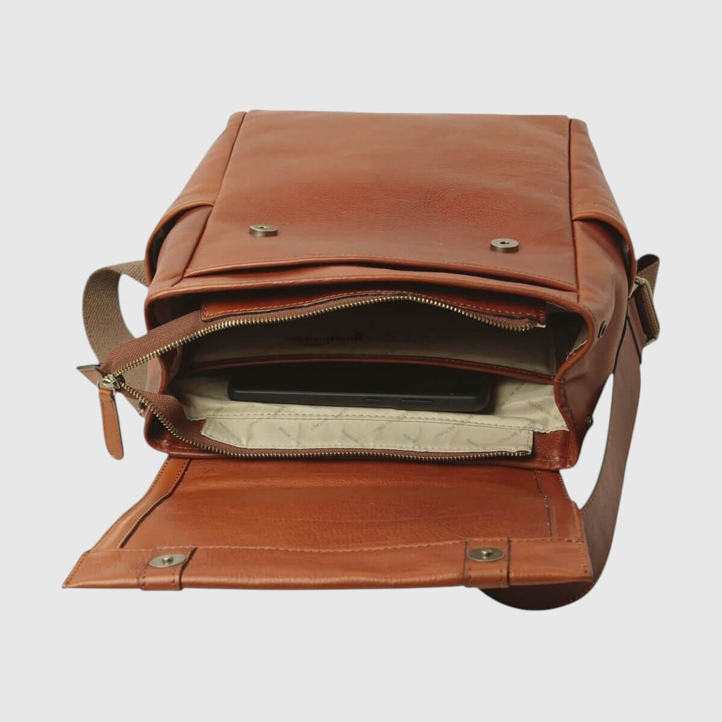 Zaino in pelle marrone con zip e interno chiaro, patta superiore con bottoni.