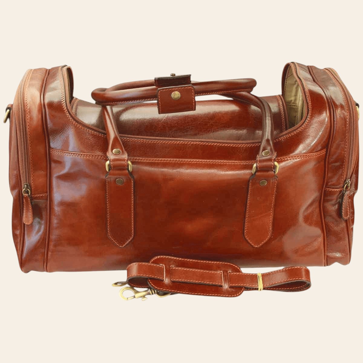 Borsa da viaggio in pelle marrone con tasca frontale e tracolla con fibbia.