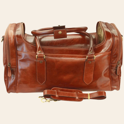 Borsa da viaggio in pelle marrone con tasca frontale e tracolla con fibbia.
