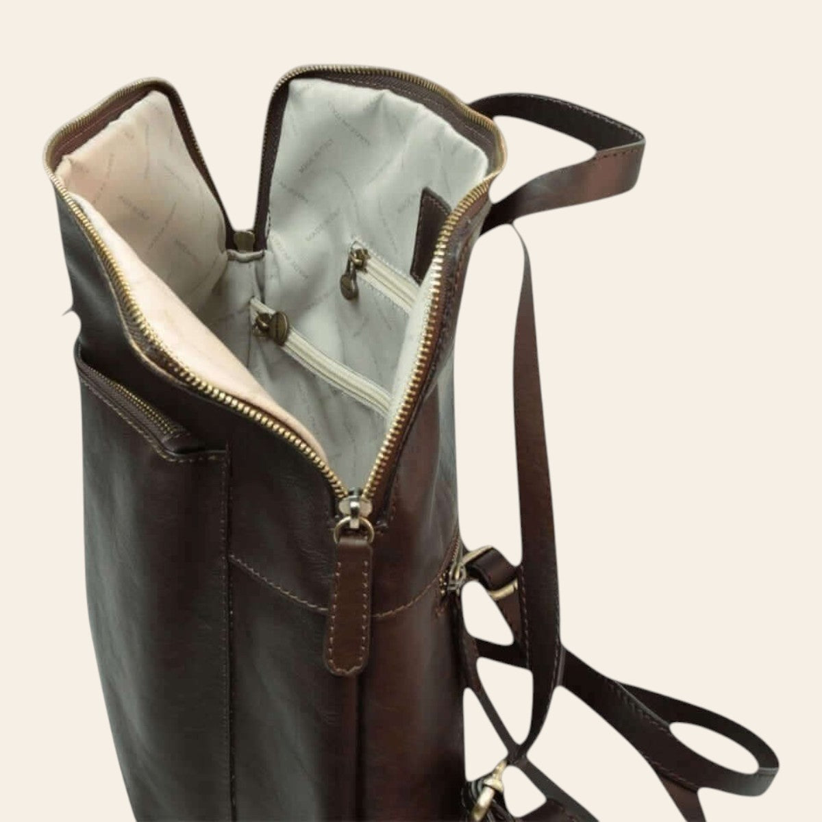 Zaino marrone scuro aperto: interno chiaro con tasche e cerniera