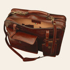 Cartella in pelle marrone vista laterale, tasche con fibbie e tracolla in cuoio