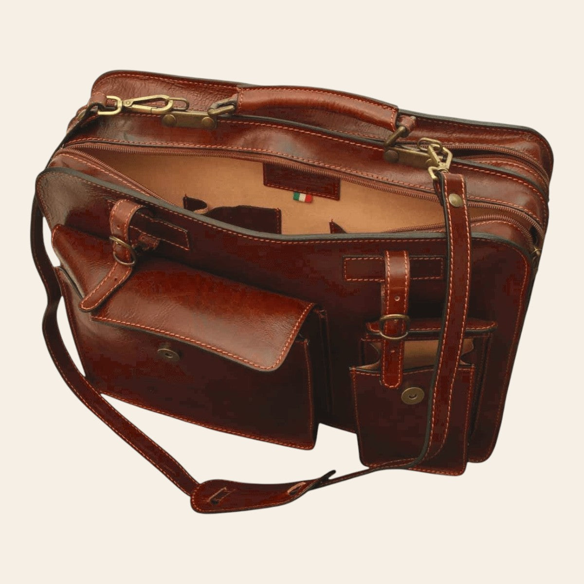 Cartella in pelle marrone vista laterale, tasche con fibbie e tracolla in cuoio