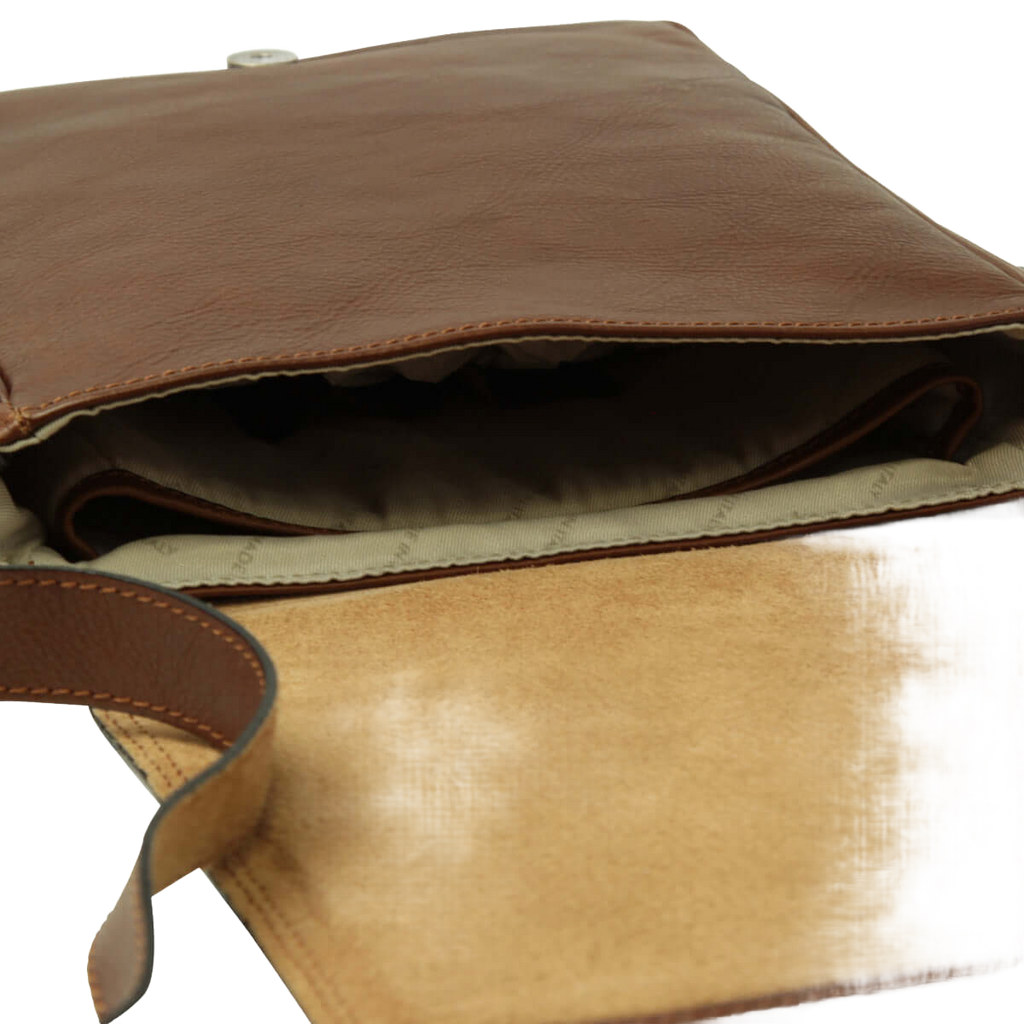 Borsa in pelle marrone con interno beige e bordo cucito, vista dall’apertura.