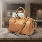 Bauletto in pelle color cuoio con due manici e tracolla lunga, fibbia frontale