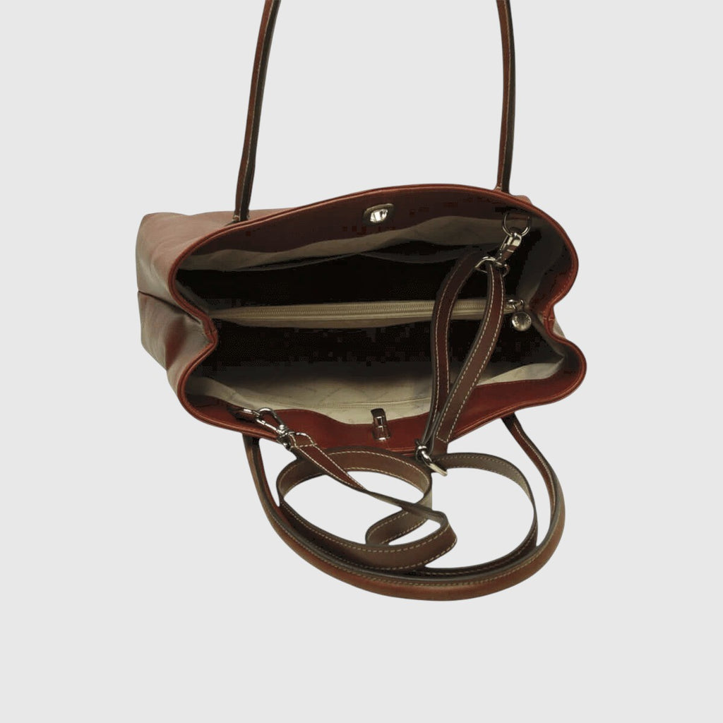 Borsa in pelle marrone vista dall’alto, interni scuri e dettagli metallici