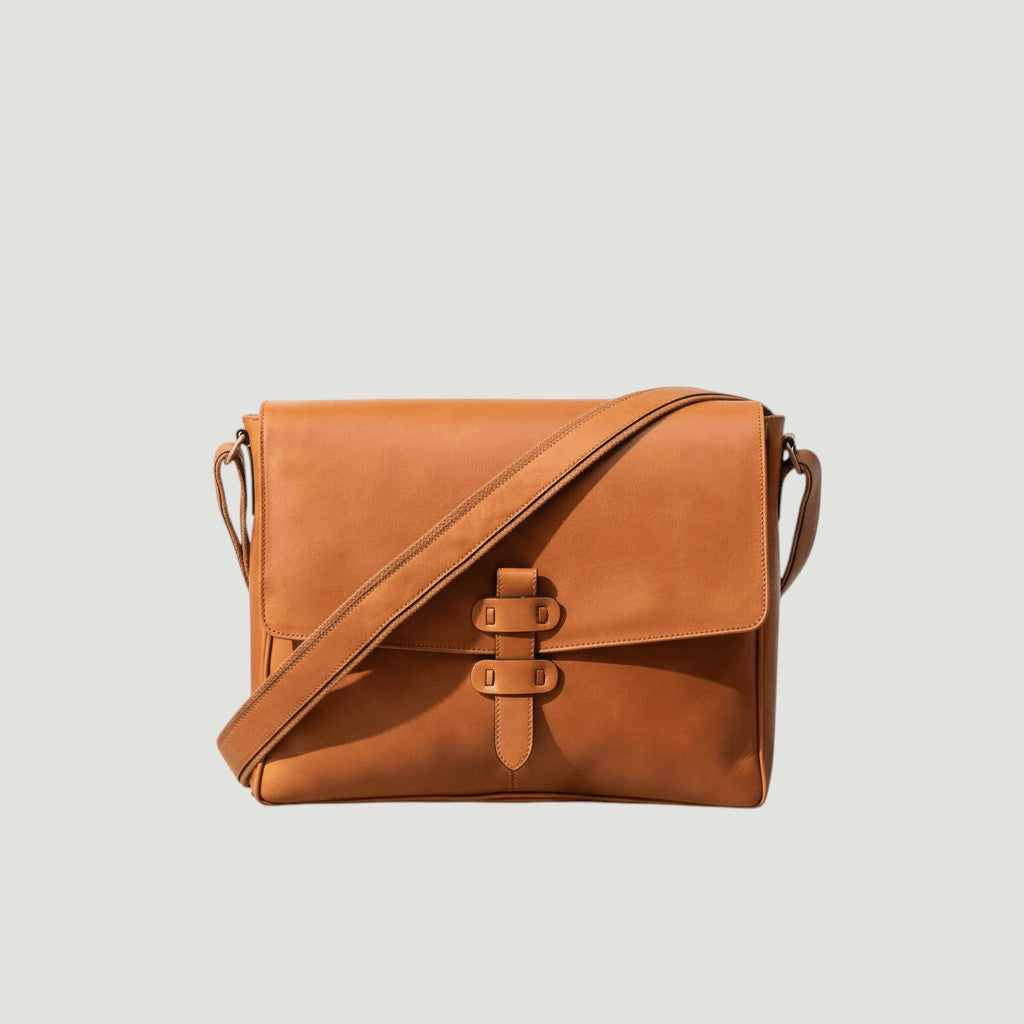 Borsa messenger in pelle marrone con tracolla e chiusura a fibbia sul davanti.