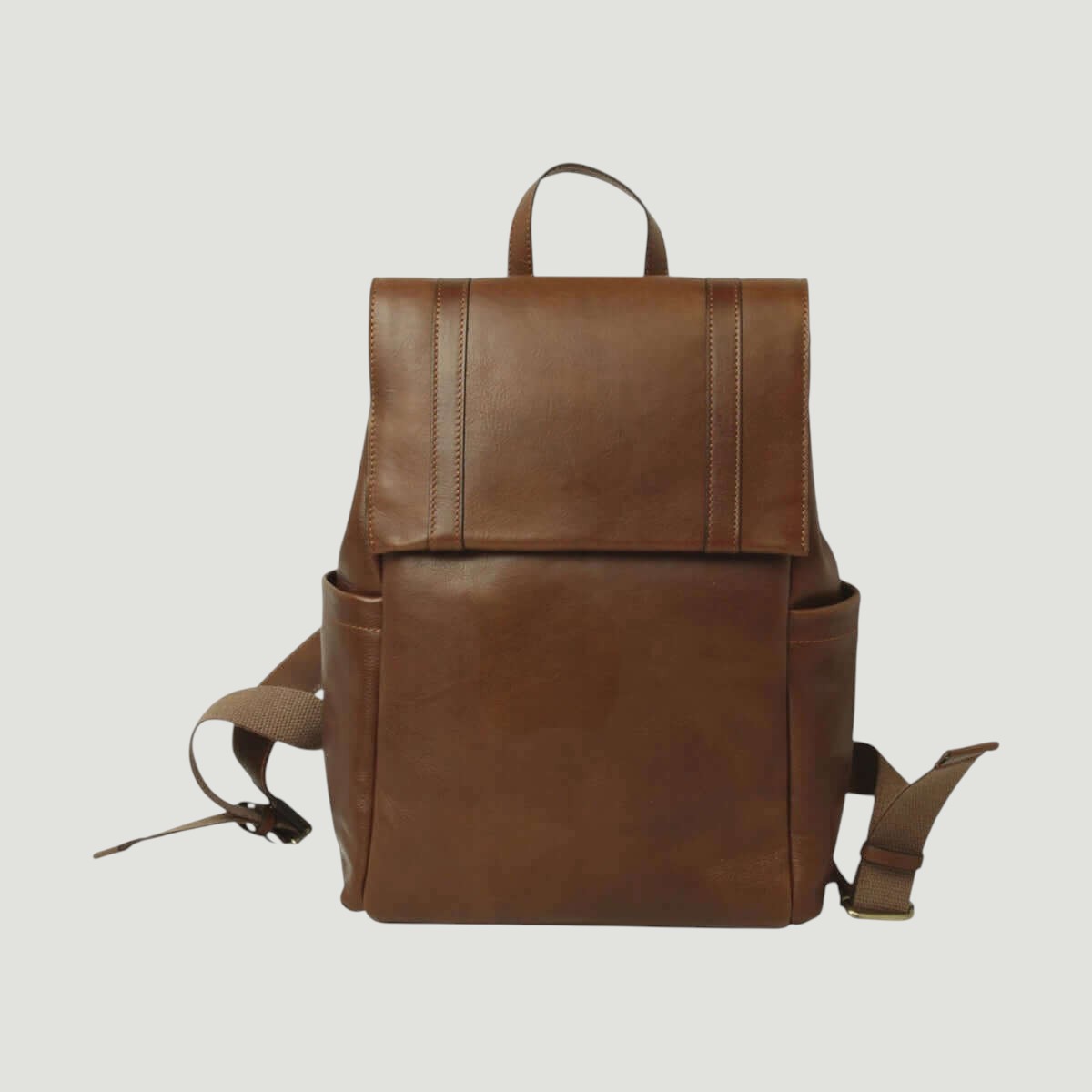 Zaino in pelle marrone con patta frontale e tasca esterna, tracolle regolabili.