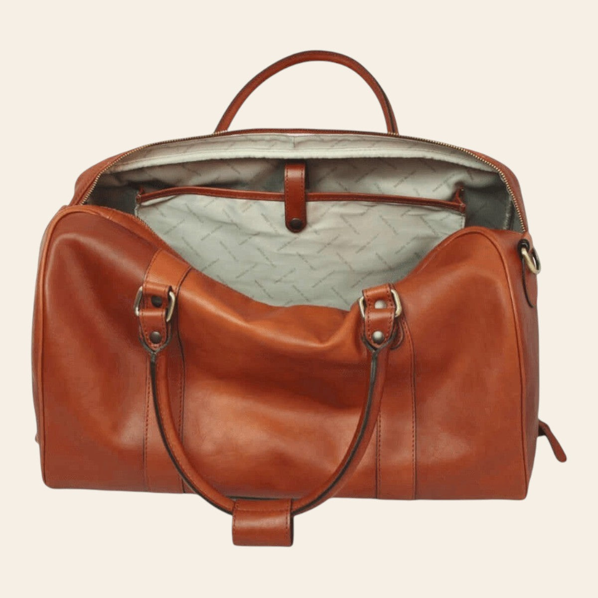 Sac de voyage en cuir cognac chaud, ouvert avec doublure claire imprimée et poche intérieure à patte en cuir