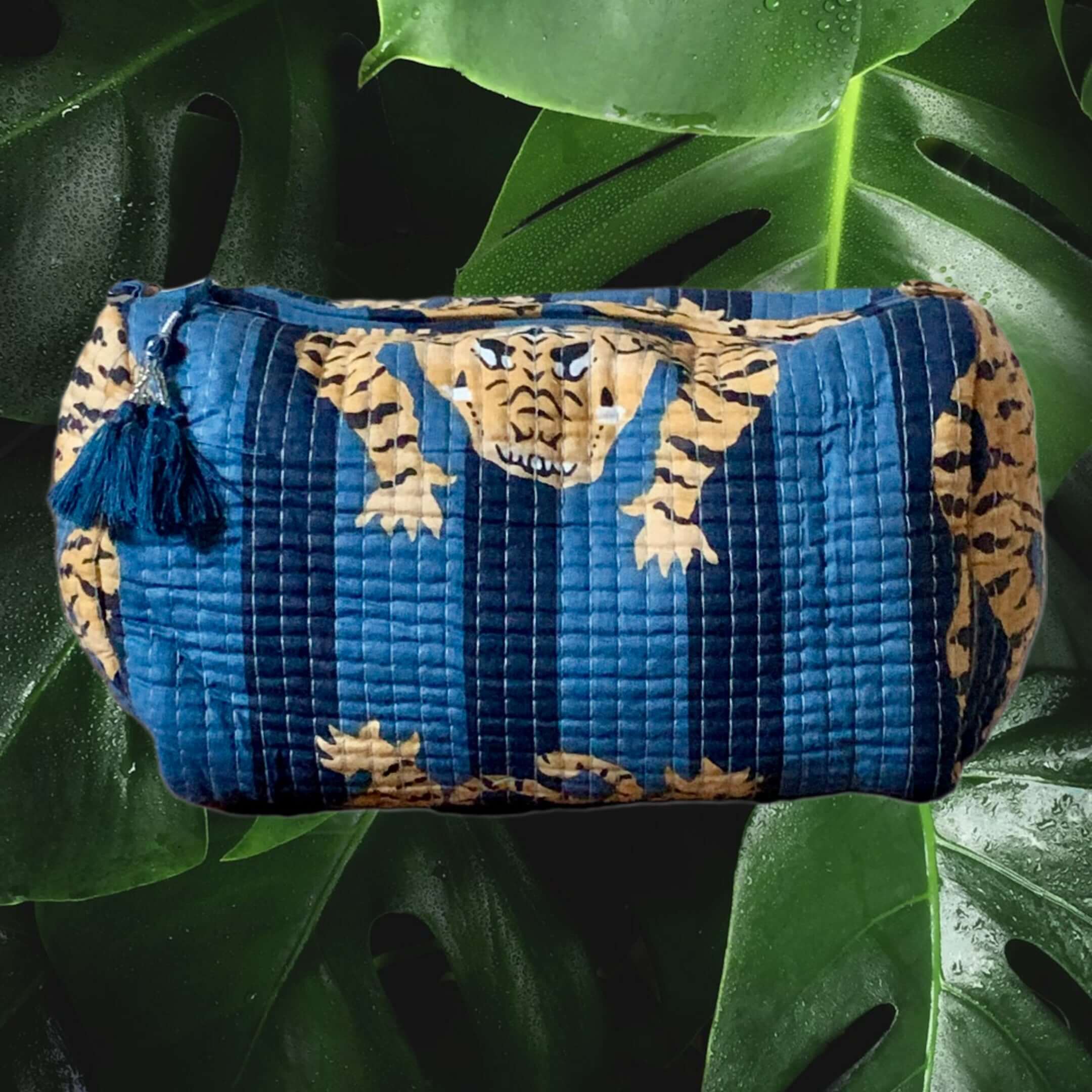 Pochette da Viaggio Roary Pouches Tigers on Blue with bold tiger pattern and tassel detail against green leaves.