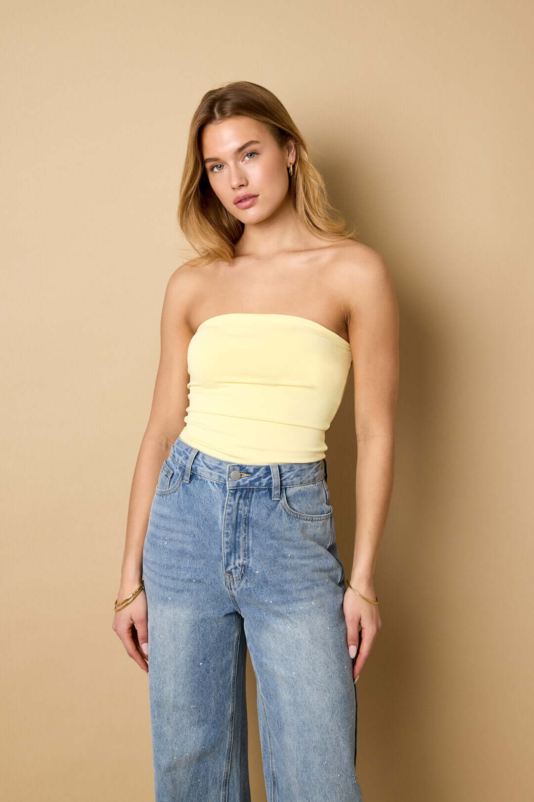 Top a fascia giallo chiaro senza spalline, arricciature orizzontali.