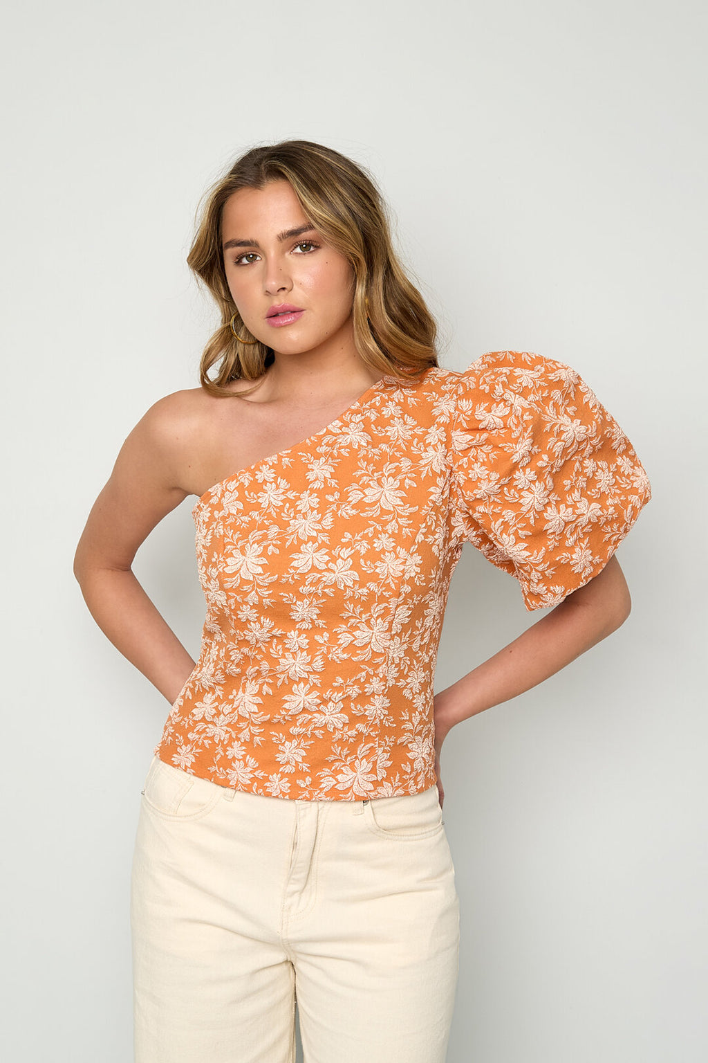 Top a fiori monospalla in tessuto arancione con manica puff per una moda primavera/estate elegante.
