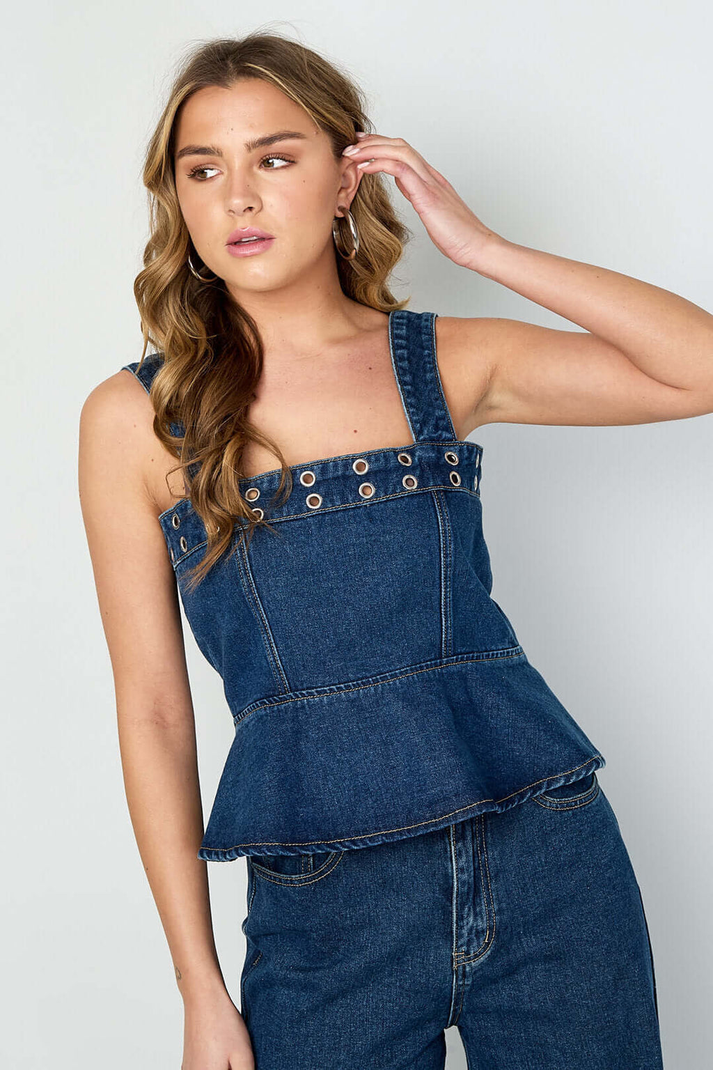 Top in denim blu con occhielli, scollo quadrato e volant a balze