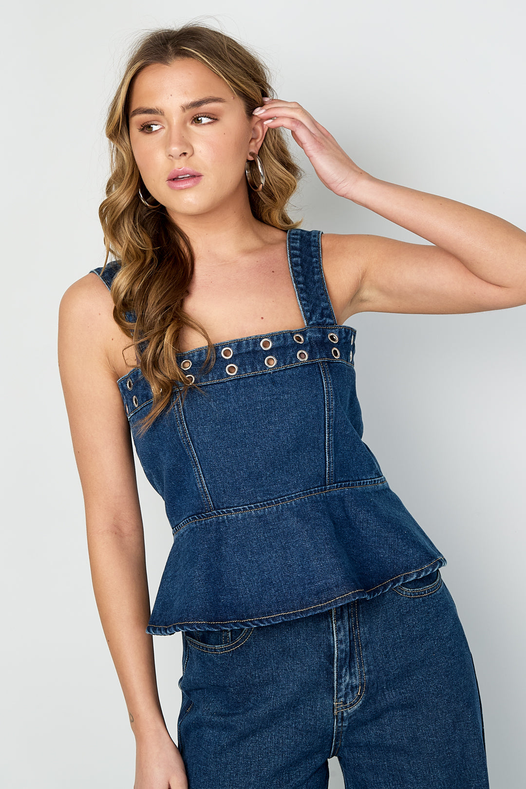 Top in denim con occhielli