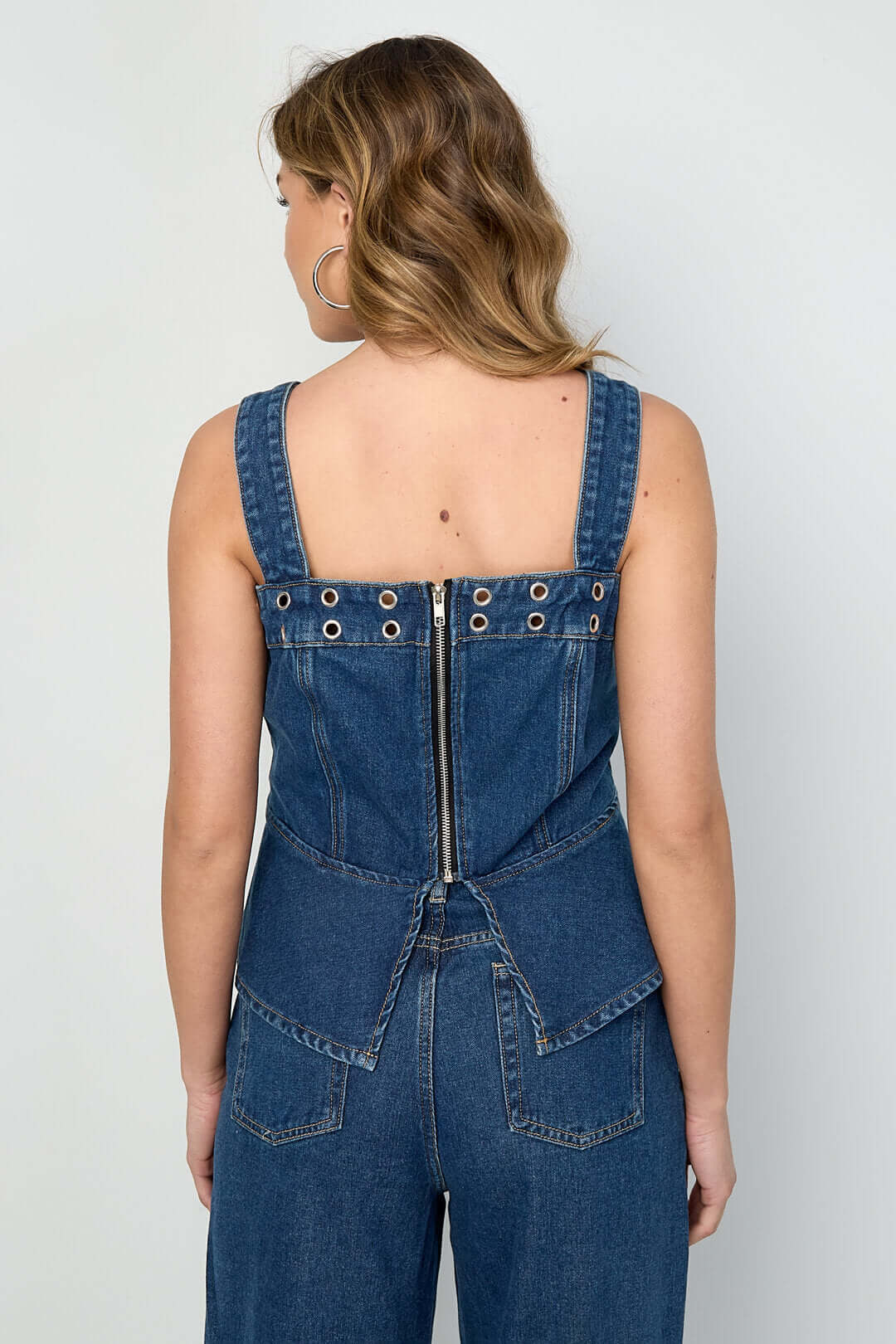 Top in denim blu con occhielli sul retro, spalline larghe e cuciture