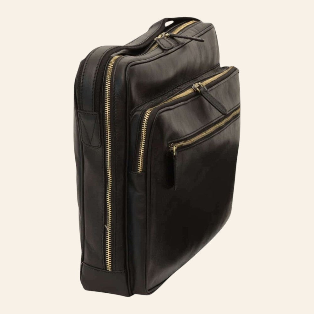 Detail einer Messenger-Tasche aus vollnarbigem Kalbsleder in Schwarz mit messingfarbenen Reißverschlüssen