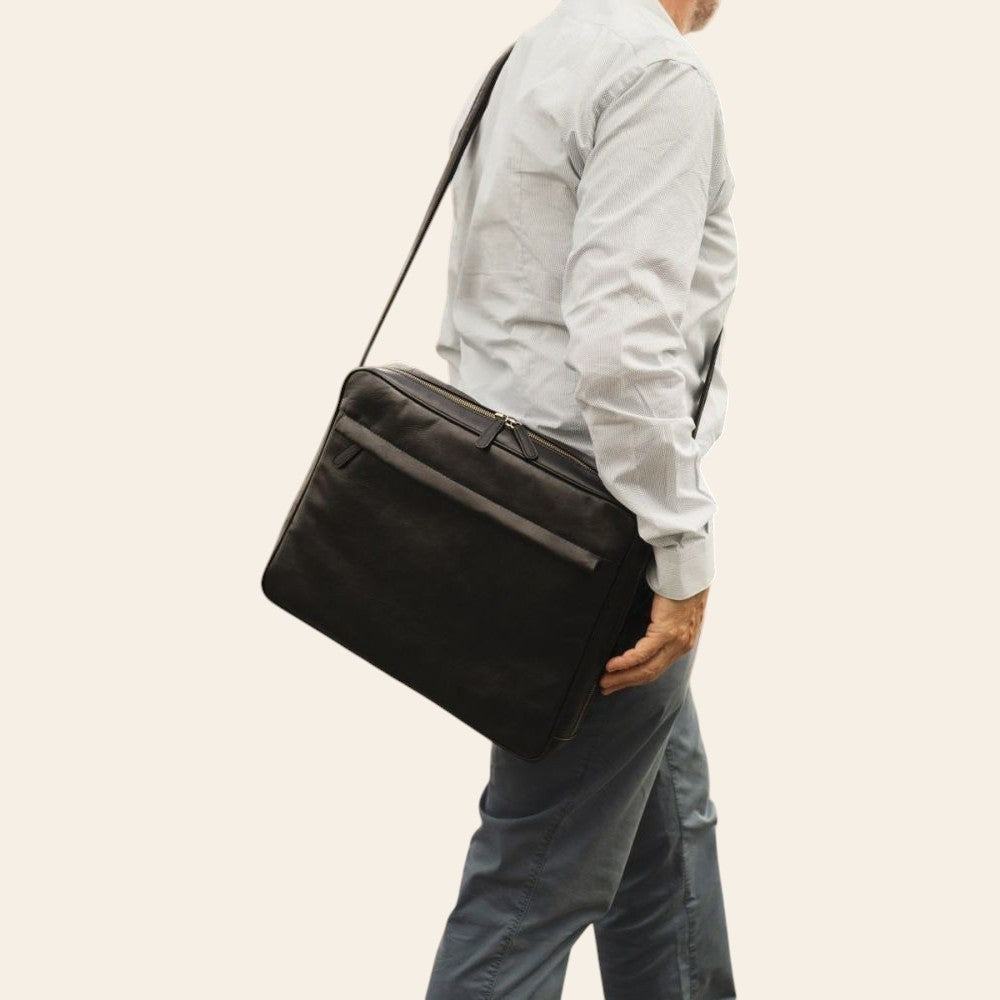 Uomo che indossa una borsa messenger Vetrina Fiorentina in pelle di vitello nera artigianale con tracolla regolabile