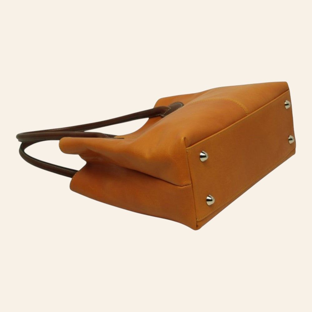 Tasche aus Vollnarbenleder in Ockergelb mit braunen Henkeln und Metallfüßen