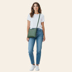 Modella indossa borsa a tracolla Vetrina Fiorentina in pelle verde pieno fiore con zip, stile casual urbano