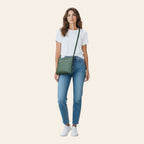 Modella indossa borsa a tracolla Vetrina Fiorentina in pelle verde pieno fiore con zip, stile casual urbano
