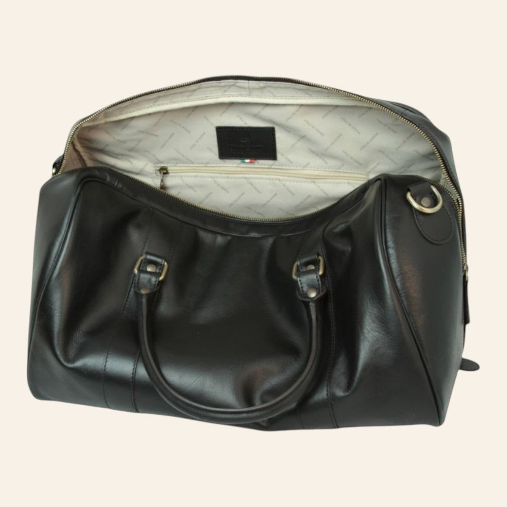 Bolsa de viaje de piel negra, abierta con forro claro estampado y bolsillo interior con cremallera