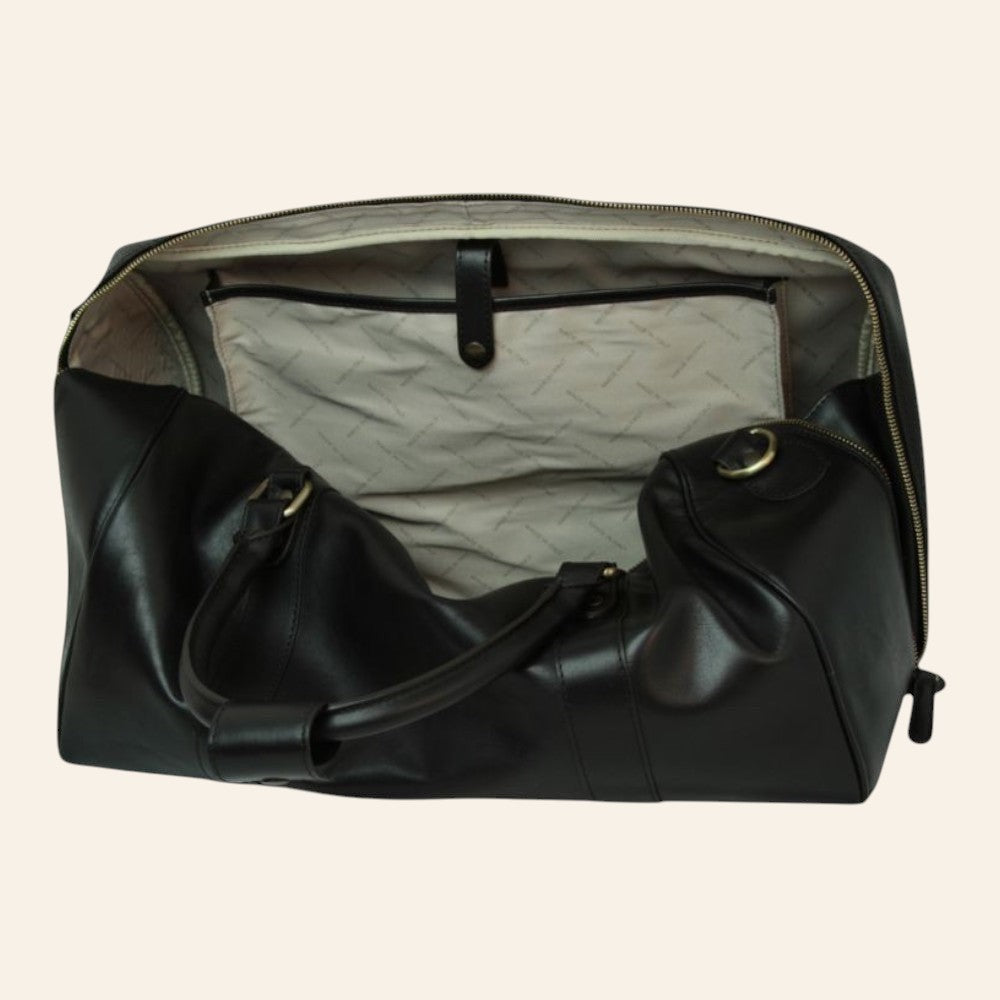 Bolsa de viaje de piel negra, abierta con forro claro estampado y amplio separador interior